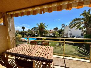 een balkon met een tafel en uitzicht op een zwembad bij BOOK MEDITERRANI CAMBRILS in Cambrils