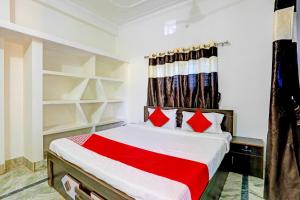 um quarto com uma cama grande e almofadas vermelhas em Super OYO Flagship Namaskar Cozzy Cottage em Bhubaneshwar