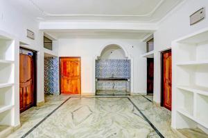 um corredor com portas de madeira e pisos em mármore em Super OYO Flagship Namaskar Cozzy Cottage em Bhubaneshwar