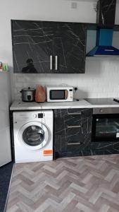 una cucina con lavatrice e forno a microonde di Studio Flat 2 Nelson Town Centre a Nelson