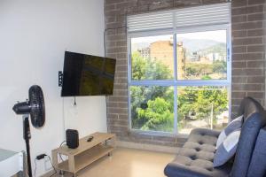 uma sala de estar com um sofá e uma grande janela em Laureles Estadio 2 Alc Apartamento completo 501 em Medellín