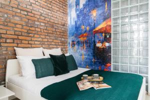 - une chambre avec un lit et un mur en briques dans l'établissement Rotunda Apartment by LoftAffair, à Cracovie