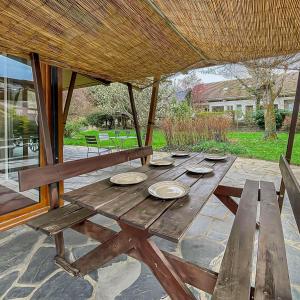 - une table de pique-nique en bois sous un toit de paille dans l'établissement Chalet entre Lac d'Annecy et Montagnes, à Écharvine