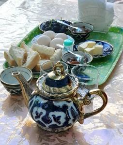 a teapot sitting on a table with eggs and bread at Hotel Zuxritdin with XIX century museum in Bukhara