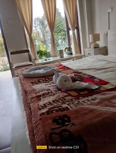 a stuffed animal laying on a bed in a bedroom at BN Resort in Gangolihāt