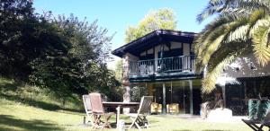 a house with a table and chairs in the yard at Domaine Xixtaberri in Cambo-les-Bains