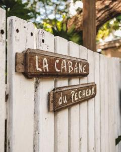 płot z dwoma znakami na górze w obiekcie La Cabane du Pecheur w mieście Black River