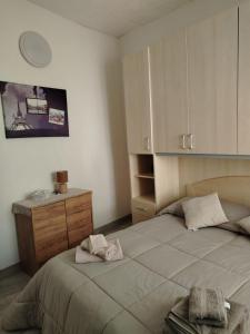 a bedroom with a large bed and a dresser at LOFT in Mezzolombardo