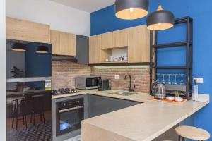 a kitchen with a counter and a blue wall at Alice 2-BR in Mar Mikhael in Beirut