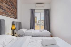 a hotel room with two beds and a window at Alice 2-BR in Mar Mikhael in Beirut