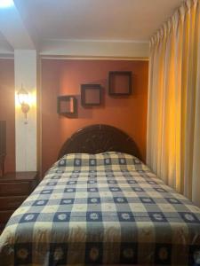 1 dormitorio con 1 cama con manta azul y blanca en HOTEL ARC&SUITE, en Tacna