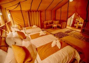 a bedroom with three beds in a room at Global Luxury Camp in Merzouga