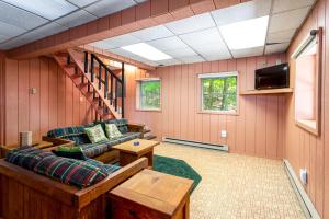 - un salon avec un canapé et une télévision dans l'établissement Hot Tub, Huge Deck, WiFi, Fire Pit at Chalet Cabin, à Morton Grove