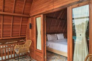 - une chambre dans une maison en bois avec un lit dans l'établissement Plumeria NP, à Nusa Penida