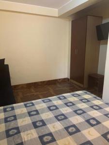 sypialnia z łóżkiem z niebiesko-białą kołdrą w obiekcie HOTEL ARC&SUITE w mieście Tacna