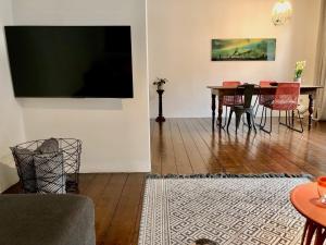 杜伊斯堡的住宿－Apartments "Am Rheinorange", Netflix, Amazon Prime，客厅设有一张带红色椅子的餐桌