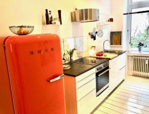 a kitchen with an orange refrigerator in a kitchen at Apartments "Am Rheinorange", Netflix, Amazon Prime in Duisburg