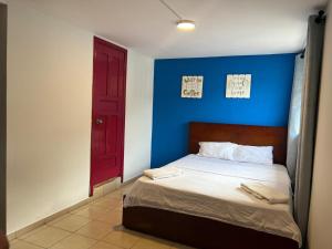 um quarto com uma cama e uma porta vermelha em Town Apartment with terrace 4 bedrooms 3 baths em Baños