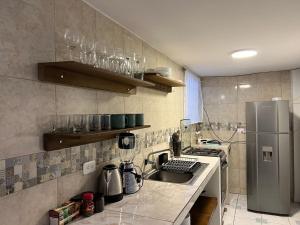cocina con fregadero y nevera en Town Apartment with terrace 4 bedrooms 3 baths, en Baños