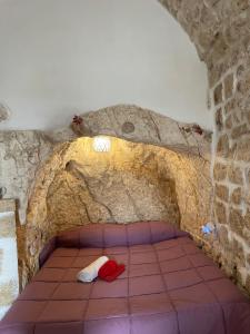 a room with a bed in a stone wall at Casa Mimmo in Ostuni