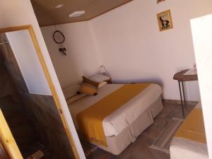 1 dormitorio con 1 cama en una habitación pequeña en Casa Ñawi en San Pedro de Atacama