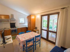 une cuisine avec une table et des chaises bleues ainsi qu'une salle à manger dans l'établissement Casa vacanze Rugiada, à Porto Pollo