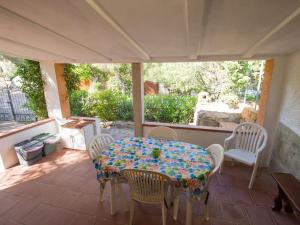 - une table et des chaises sur une terrasse couverte avec une table, une table et des chaises dans l'établissement Casa vacanze Rugiada, à Porto Pollo