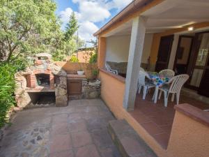 a patio with a stone fireplace on a house at Casa vacanze Rugiada Porto Pollo in Porto Pollo