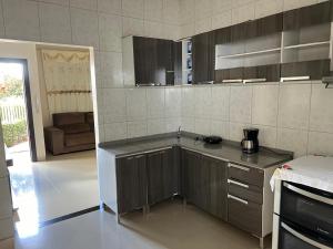 uma cozinha com armários de madeira e uma bancada em Casa Mobiliada Itaubas com ar condicionado em Sinop