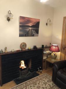 a fireplace in a living room with a fire place at Spiddal Cottage in Spiddal
