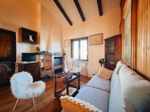 Mansarda Val di Sangro في Rocca Cinquemiglia: غرفة معيشة مع أريكة وكرسيين