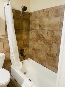 Super Inn Downtown في باردستاون: حمام مع حوض استحمام ومرحاض