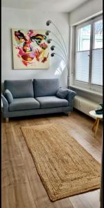 sala de estar con sofá azul y alfombra en LITZI Apartment, en Baden-Baden