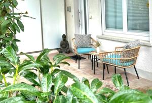 Un porche con dos sillas y una estatua. en LITZI Apartment en Baden-Baden