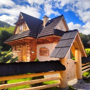 une cabane en rondins avec un toit noir dans l'établissement Domek Trzy Doliny Zakopane - Three Valleys Chalet Grill&Jacuzzi, à Zakopane
