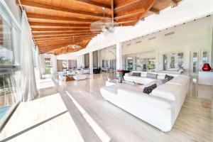 a living room with white furniture and large windows at Casa de Campo Elegance - 8-Bedroom Golf View Villa in La Romana