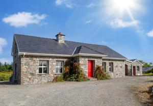 a stone house with a red door at Sycamore Cottage in Clifden