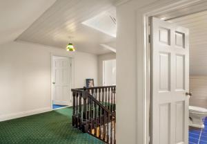 a hallway with a staircase and a toilet in a house at Sycamore Cottage in Clifden