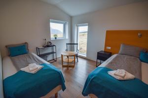 Zimmer mit 2 Betten, einem Tisch und einem Fenster in der Unterkunft Glacier World - Hoffell Guesthouse in Hoffell