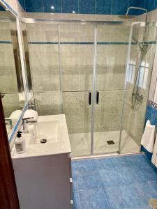 La salle de bains est pourvue d'une douche et d'un lavabo. dans l'établissement Chalet con piscina El Refugio de Venecia, à El Campillo