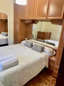 sypialnia z dużym łóżkiem i lustrem w obiekcie Chalet con piscina El Refugio de Venecia w mieście El Campillo