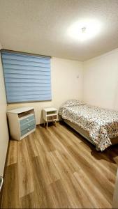 um quarto com uma cama e uma televisão em Jardines del Pacífico 3 em La Serena