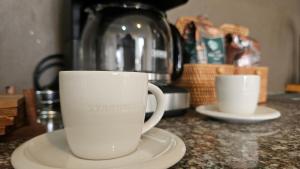 dos tazas de café blancas sentadas en un mostrador en Jardines del Pacífico 3, en La Serena