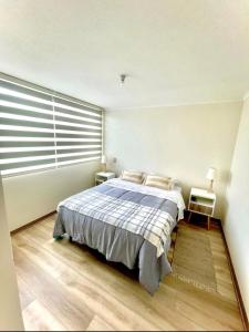 1 dormitorio con cama y ventana grande en Jardines del Pacífico 3, en La Serena