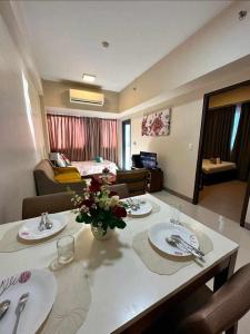 a living room with a table with plates and flowers on it at Relaxing SEA VIEW condo Mactan Newtown in Punta Engaño