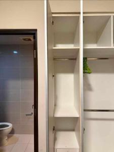 a bathroom with a toilet and a closet with shelves at Relaxing SEA VIEW condo Mactan Newtown in Punta Engaño
