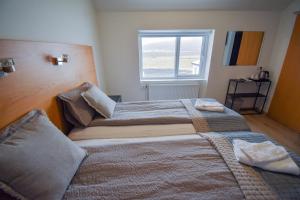 A bed or beds in a room at Glacier World - Hoffell Guesthouse