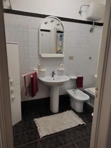 a bathroom with a sink and a toilet and a mirror at La Villetta in Cutrofiano