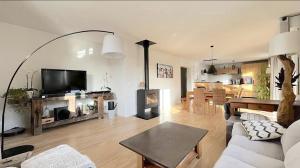 a living room with a couch and a fireplace at Maison entre lac et montagnes in Quintal