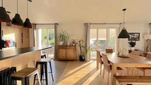 eine Küche und ein Esszimmer mit einem Tisch und Stühlen in der Unterkunft Maison entre lac et montagnes in Quintal